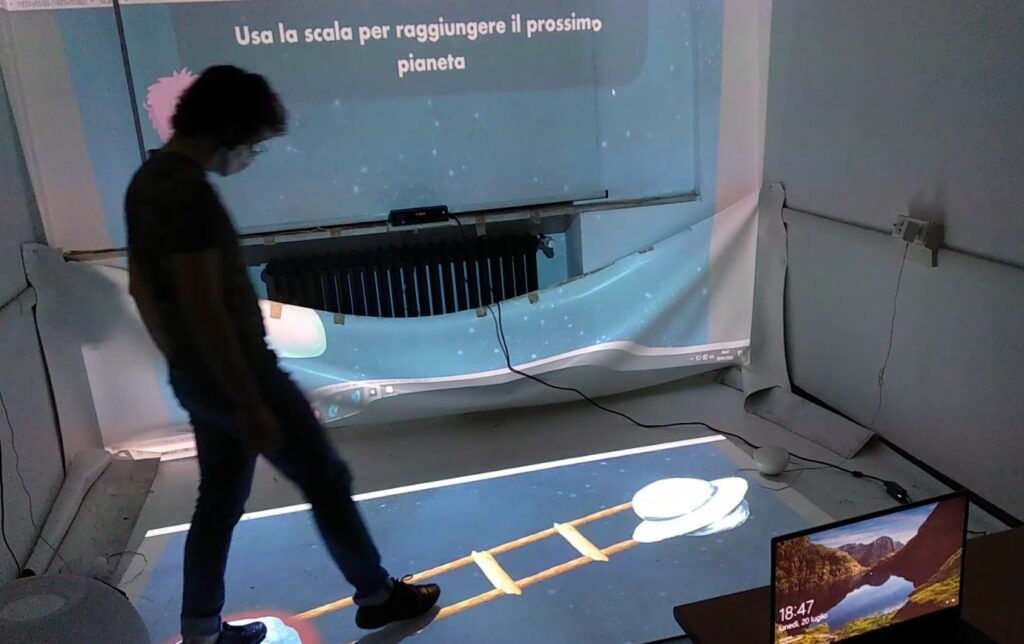 A guy is playing the Exergame in the magic room. Emi is asking the user to reach the next planet using the ladder. On the floor two planets are displayed and are connected by a ladder. The user is positioning his right foot on the first rung.