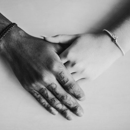 Two peoples' hands caressing each other.